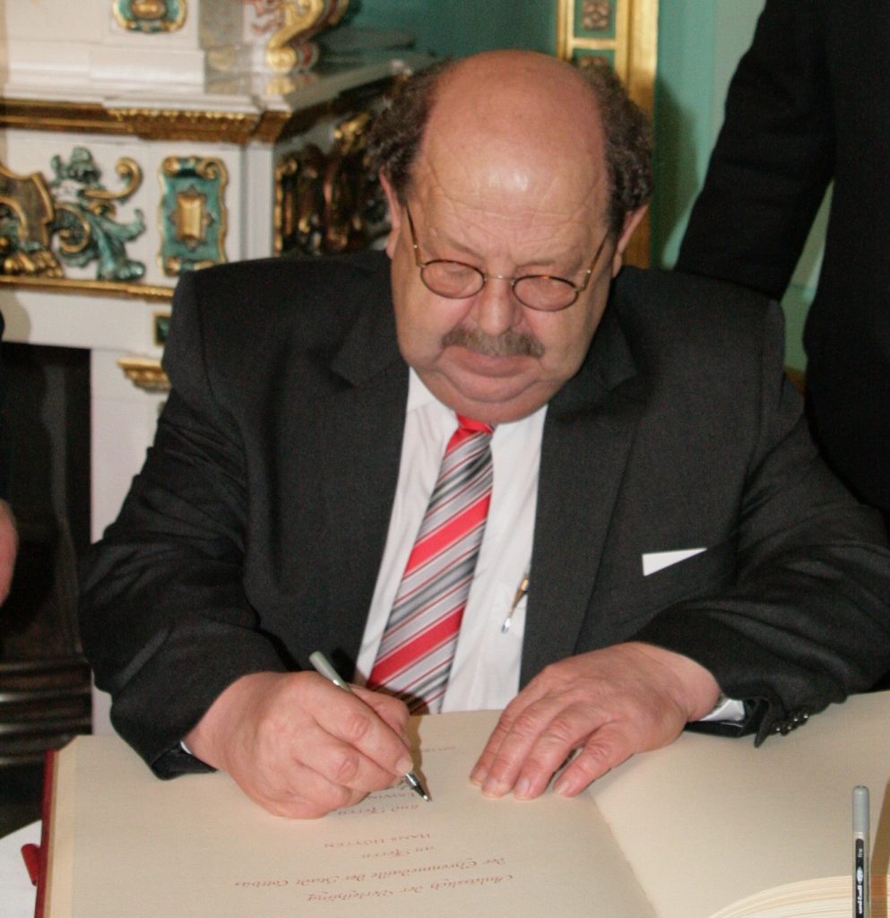 Hans Hütten trägt sich ins Goldene Buch der Stadt Cottbus ein.